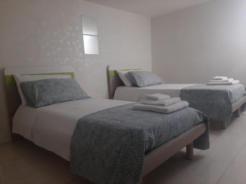 two beds in a bedroom with towels on them at Dimora dAmare in Trani