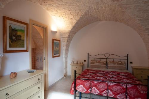- une chambre avec un lit et un mur en briques dans l'établissement B&B Masseria SERRI, à Putignano