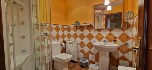 y baño con aseo, lavabo y espejo. en Apartamentos Casa Bárbora, en Villaviciosa