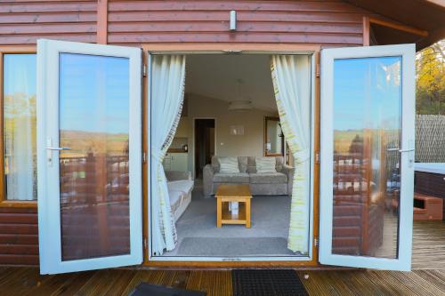 an open door of a house with a living room at Devon Bliss Pool View Lodge at Finlake Resort in Chudleigh