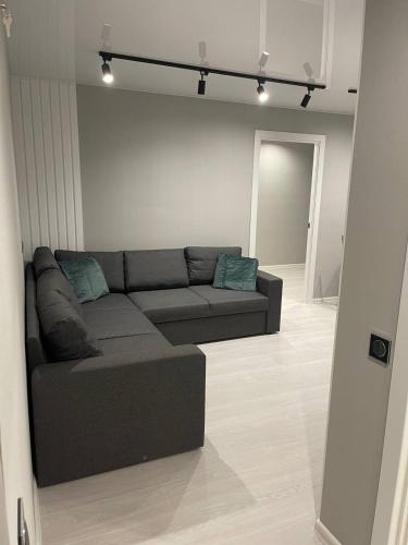 a living room with a gray couch in a room at пр. Металургів 19 in Kryvyi Rih