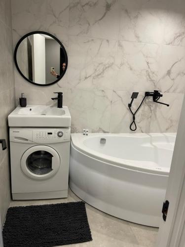 a bathroom with a white tub and a washing machine at пр. Металургів 19 in Kryvyi Rih