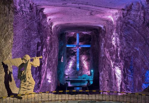 a statue of a man with a cross in a cave at Hotel Salinero - Zipaquirá in Zipaquirá