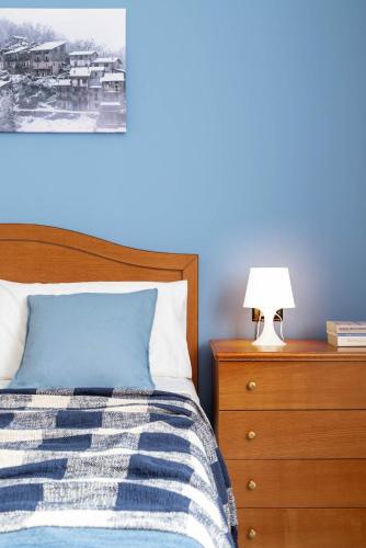 a bedroom with a bed and a lamp on a dresser at CasaLina in Berbenno di Valtellina