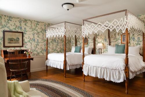 Duas camas num quarto com papel de parede floral em The Grafton Inn em Grafton