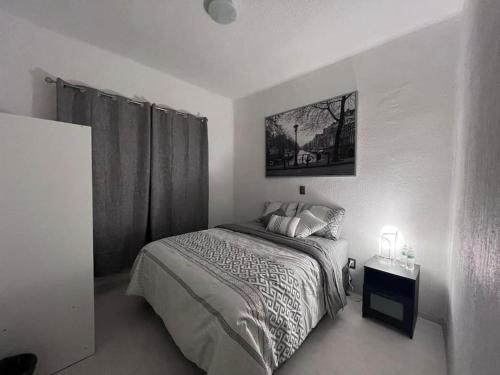 1 dormitorio con 1 cama y una foto en la pared en Departamento, en Ciudad de México