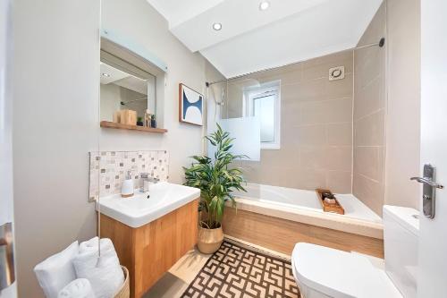 uma casa de banho com um lavatório, um WC e uma banheira em 1BD apartment in Leyton zone 2 em Londres