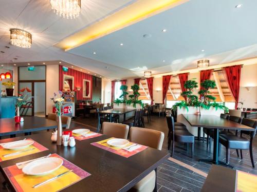 a dining room with tables and chairs in a restaurant at Landal Residence Duna in Dunaszentmiklós