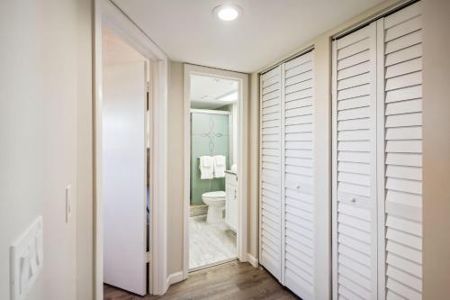 a bathroom with white closet doors and a toilet at Bayshore Yacht & Tennis 409 - Premier in Clearwater Beach
