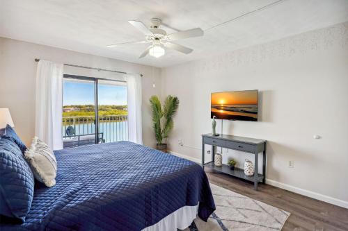 a bedroom with a blue bed and a window at Bayshore Yacht & Tennis 409 - Premier in Clearwater Beach