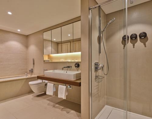 uma casa de banho com um chuveiro, um lavatório e um WC. em The Apartments by The Sloane Club em Londres