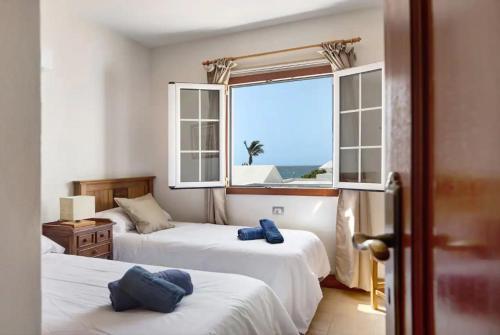 een slaapkamer met 2 bedden en een raam met uitzicht op de oceaan bij Villa Turqué in Arrieta