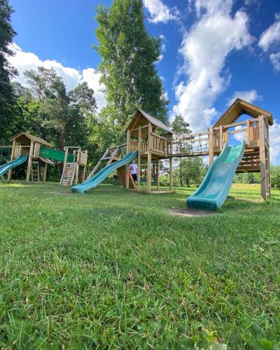 a group of playground slides in the grass at Abzali Hotel and Restaurant with self check-in in Ādaži