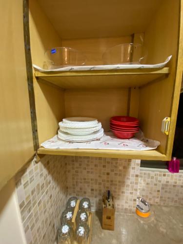 ein Regal mit Tellern und Schüsseln in der Küche in der Unterkunft 3 Bed Apartment in Karatschi