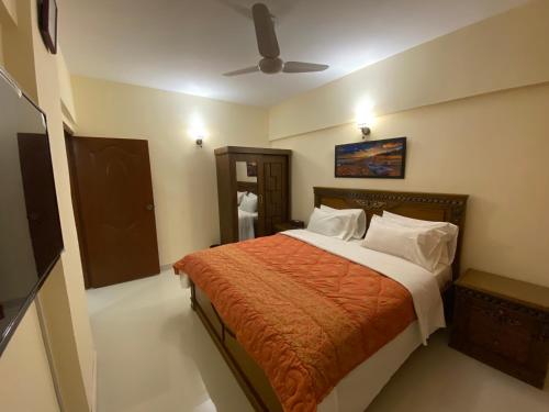 a bedroom with a bed and a ceiling fan at 3 Bed Apartment in Karachi