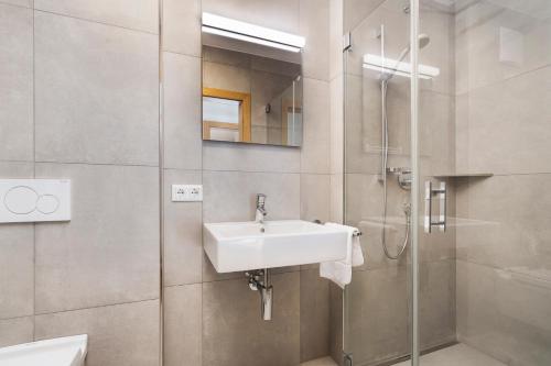 La salle de bains est pourvue d'un lavabo et d'une douche. dans l'établissement Exklusives Chalet mit Gletscherblick, à Neukirchen am Großvenediger