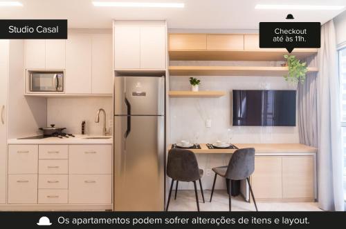 a kitchen with a refrigerator and a table and chairs at Smart Charlie Mobi Pinheiros in Sao Paulo