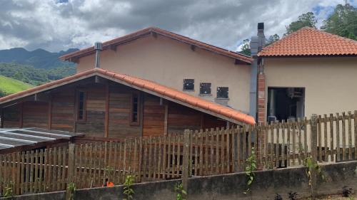 a house with a wooden fence in front of it at Pousada Renovo da Serra in São Pedro da Serra