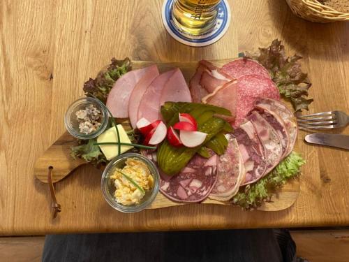 a cutting board with meat and vegetables on a table at Gasthaus Holdermühle in Creglingen