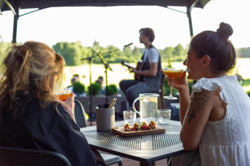 two women sitting at a table eating food at Abzali Hotel and Restaurant with self check-in in Ādaži