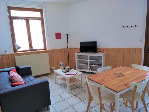 - un salon avec un canapé bleu et une table dans l'établissement Les Gîtes d'Angres - gîte n°1, à Angres