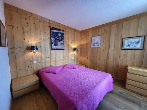 - une chambre avec un lit violet et des murs en bois dans l'établissement 2 pièces 41m², sud/ouest, à 500m des pistes avec Wifi - FR-1-449-23, à Tignes