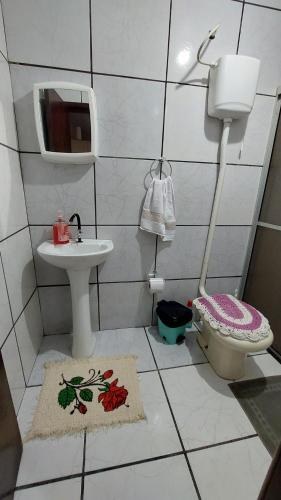 ein kleines Bad mit einem Waschbecken und einem WC in der Unterkunft Casa Canto do Farol in Navegantes