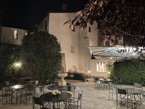a group of tables and chairs in a courtyard at night at Residenza Palazzo Fortuna - Boutique Hotel in Civita Castellana