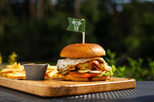 a sandwich on a cutting board with a flag on it at Abzali Hotel and Restaurant with self check-in in Ādaži