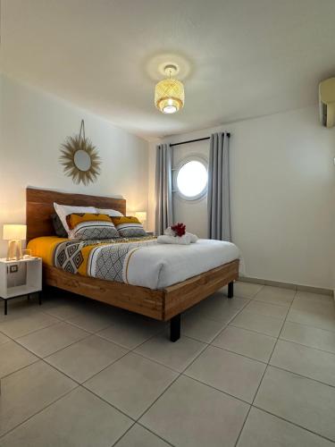 sypialnia z dużym łóżkiem i oknem w obiekcie Sunset Appart, T2 avec vue mer et plage à 1 km w mieście Le Carbet