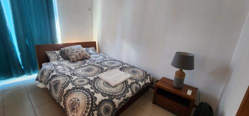 a small bedroom with a bed and a lamp at Peaceful holidays in Pereybere in Pereybere