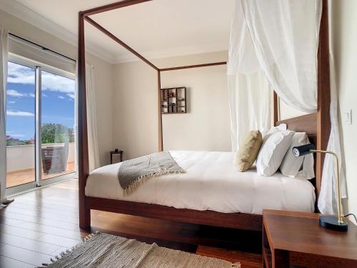 Schlafzimmer mit einem großen Bett, einem Schreibtisch und einem Fenster in der Unterkunft Ocean 59 by LovelyStay in Funchal