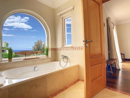 eine Badewanne im Bad mit einem großen Fenster in der Unterkunft Ocean 59 by LovelyStay in Funchal