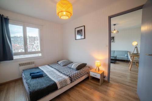 une chambre avec un lit et une grande fenêtre dans l'établissement Appartement de charme au cœur de Marseille, à Marseille