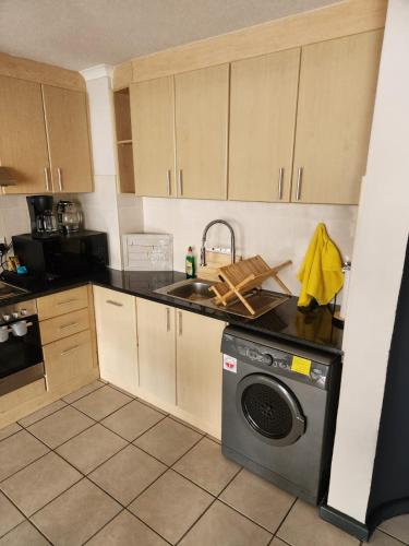 a kitchen with a sink and a washing machine at 13 at Santos in Mossel Bay