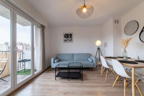 un salon avec un canapé bleu et une table dans l'établissement Appartement de charme au cœur de Marseille, à Marseille