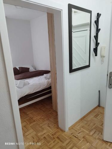 een slaapkamer met een spiegel en een bed in een kamer bij Apartman Kosta in Vrnjačka Banja
