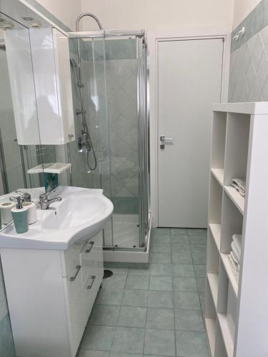 a white bathroom with a shower and a sink at Casa Marinella in Vico Equense