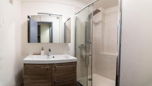 une salle de bain avec un lavabo et une douche dans l'établissement Appartement de charme au cœur de Marseille, à Marseille