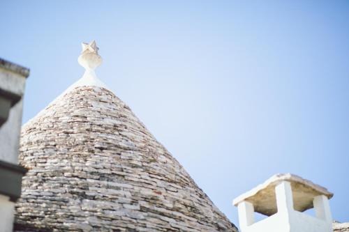 een schoorsteen van een gebouw met een blauwe lucht op de achtergrond bij Trulli Antica Fonte Luxury Suite in Alberobello