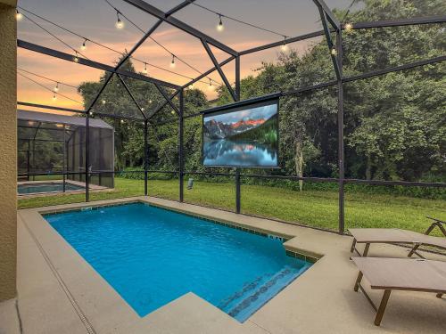 a swimming pool with a tv in a house at Marvelous Magical House: Amazing Themes and Pool, 5mi Disney in Kissimmee