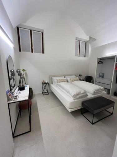 a white bedroom with a bed and a table at Immobiliare Nk Palazzo Bonvicini in Venice