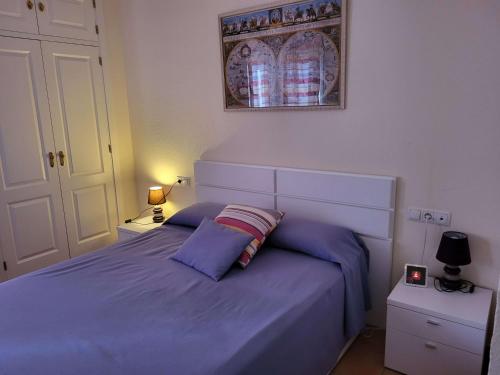 ein Schlafzimmer mit einem blauen Bett mit zwei Kissen in der Unterkunft Golf y playa en Islantilla in Huelva