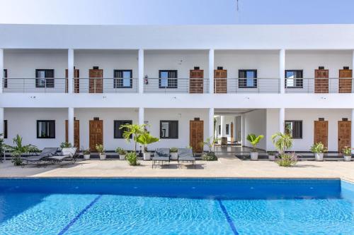 ein Hotel mit einem Pool vor einem Gebäude in der Unterkunft Hôtel le Relais de Kolda in Kolda