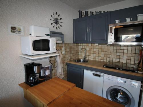 une cuisine avec un micro-ondes et un lave-linge dans l'établissement Studio cabine 4 personnes au pied des pistes avec balcon et parking - Auris en Oisans - FR-1-297-282, à Auris