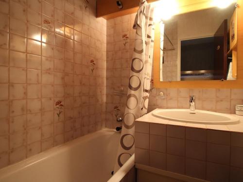 une salle de bain avec une baignoire, un lavabo et un miroir dans l'établissement Studio cabine 4 personnes au pied des pistes avec balcon et parking - Auris en Oisans - FR-1-297-282, à Auris