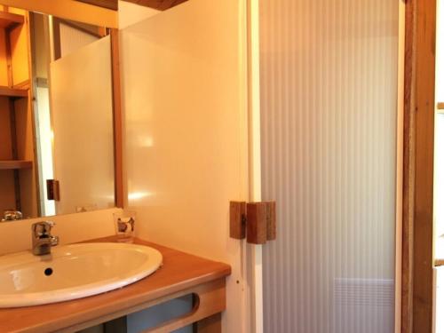 łazienka z umywalką i lustrem w obiekcie Chalets indépendants en camping 2 étoiles avec terrasse – Idéal famille, activités et jeux pour enfants - FR-1-489-405 w mieście Treignat