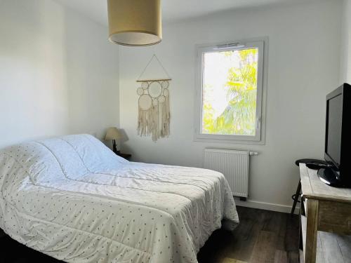 a bedroom with a bed and a window and a television at Appartement Cambo-les-Bains, 3 pièces, 4 personnes - FR-1-495-115 in Cambo-les-Bains