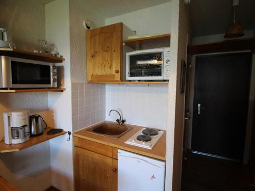 a small kitchen with a sink and a microwave at Appartement Auris, 2 pièces, 3 personnes - FR-1-297-299 in Auris