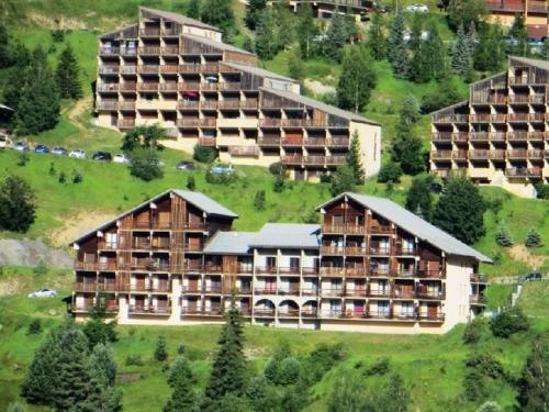 - une vue aérienne sur un complexe situé sur une colline dans l'établissement Appartement calme 2 pièces, 300m des pistes avec parking gratuit - Auris en Oisans - FR-1-297-299, à Auris